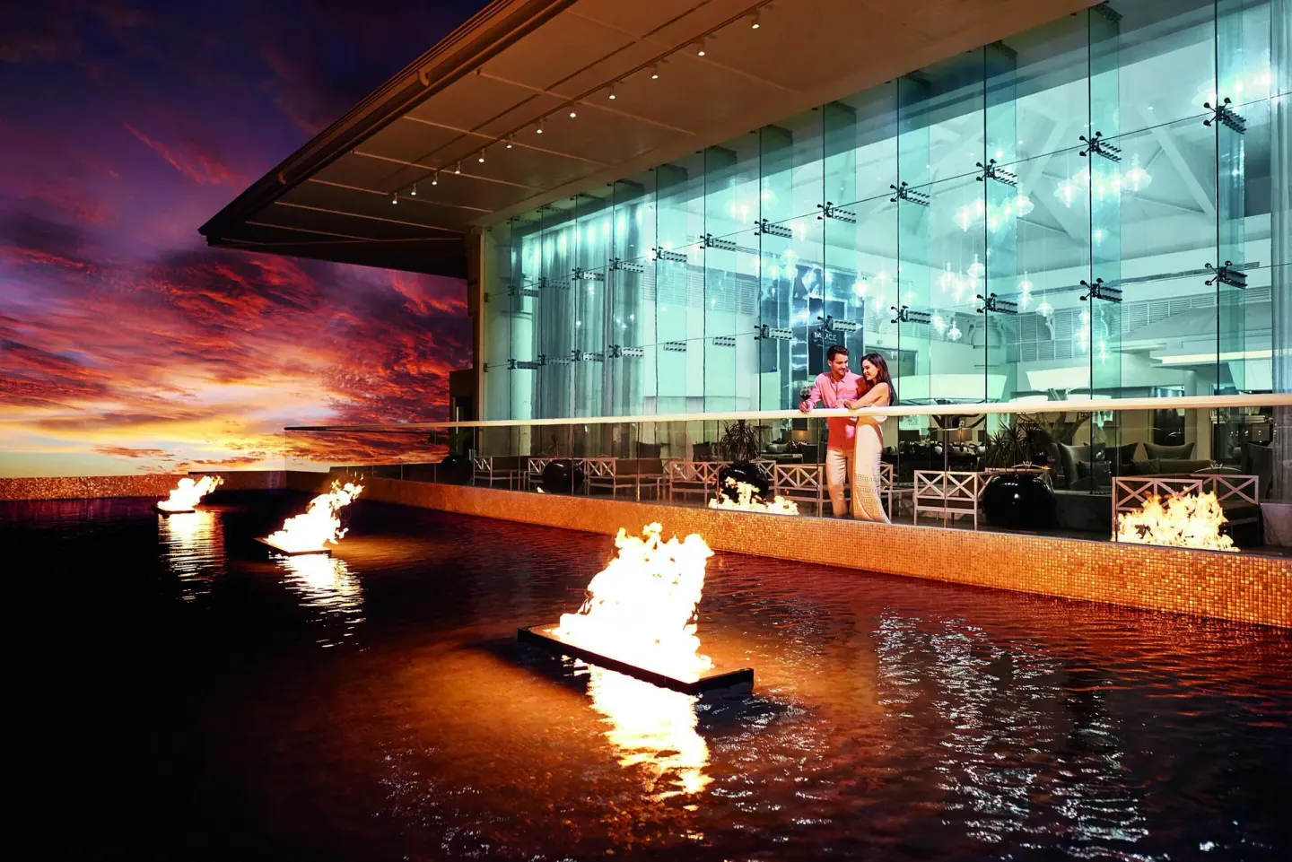 Reflecting pool with fire features outside Moon Palace Jamaica at sunset.