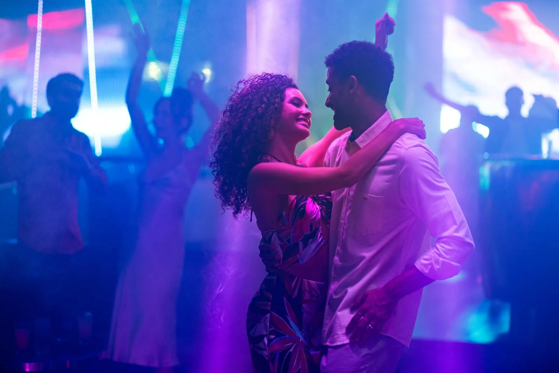 A couple dances under colorful nightclub lights at Moon Palace Jamaica.