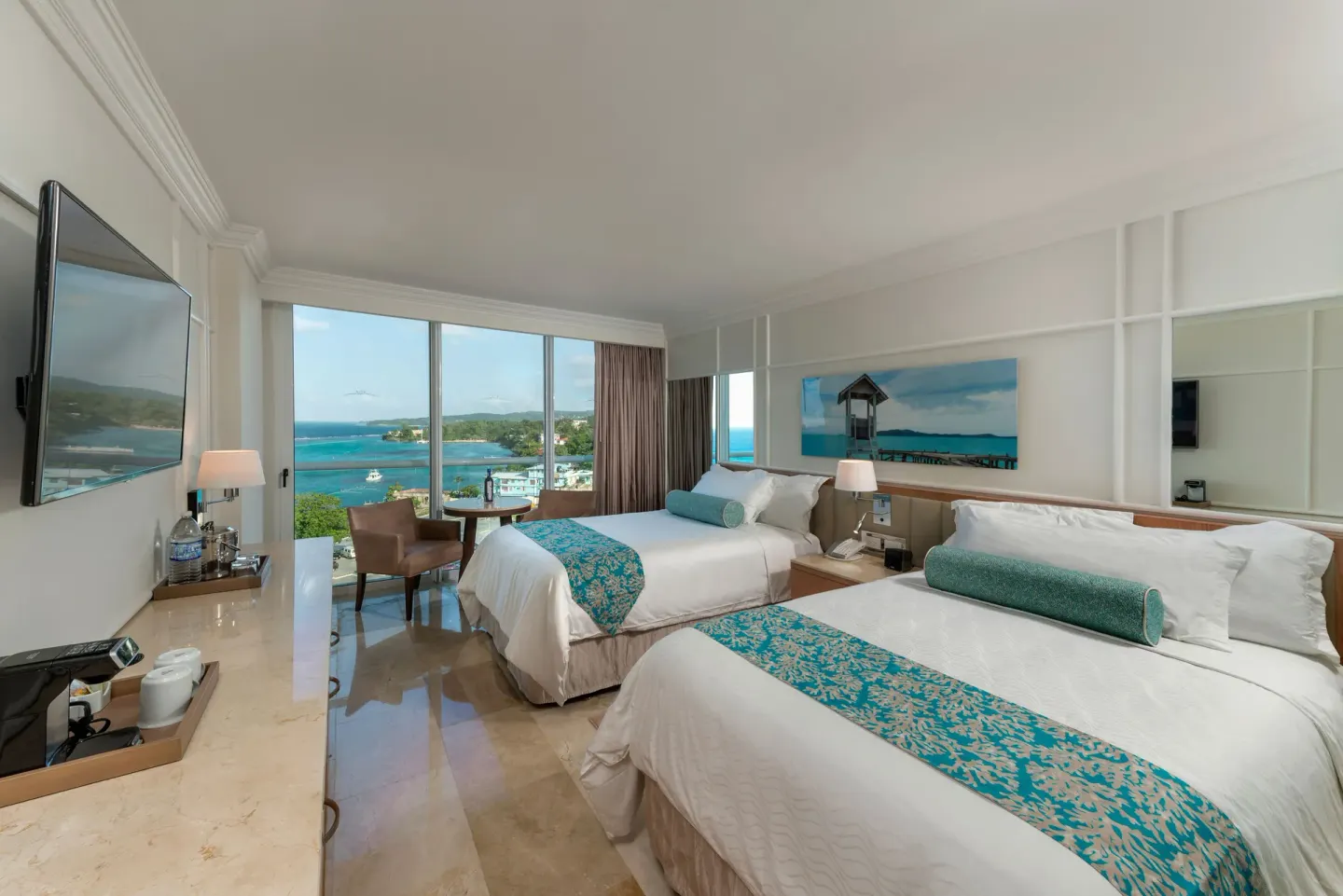 Deluxe Resort View room with two double beds and balcony windows at Moon Palace Jamaica.