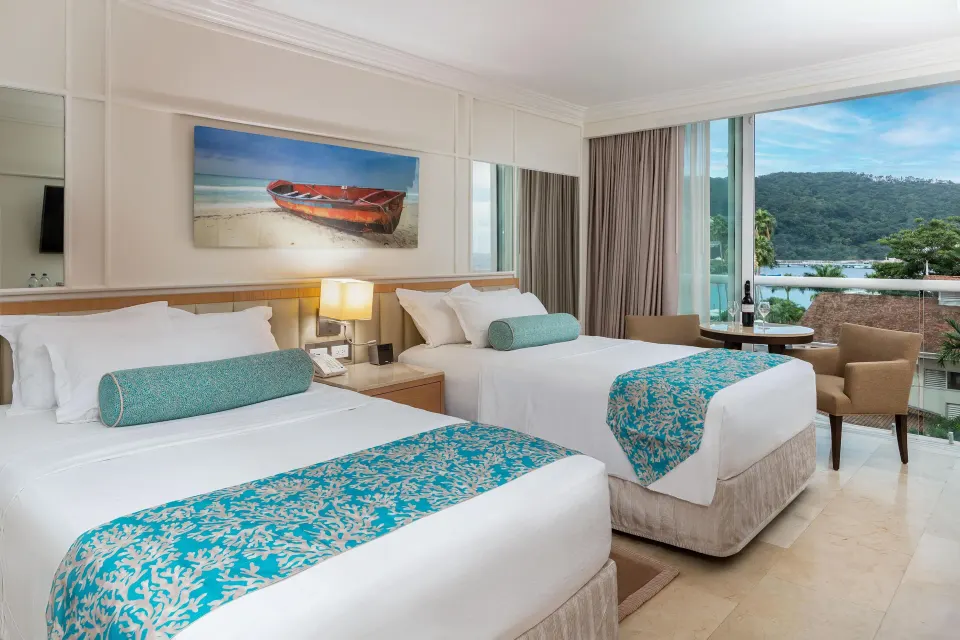 Deluxe Resort View room with two beds and balcony seating at Moon Palace Jamaica.
