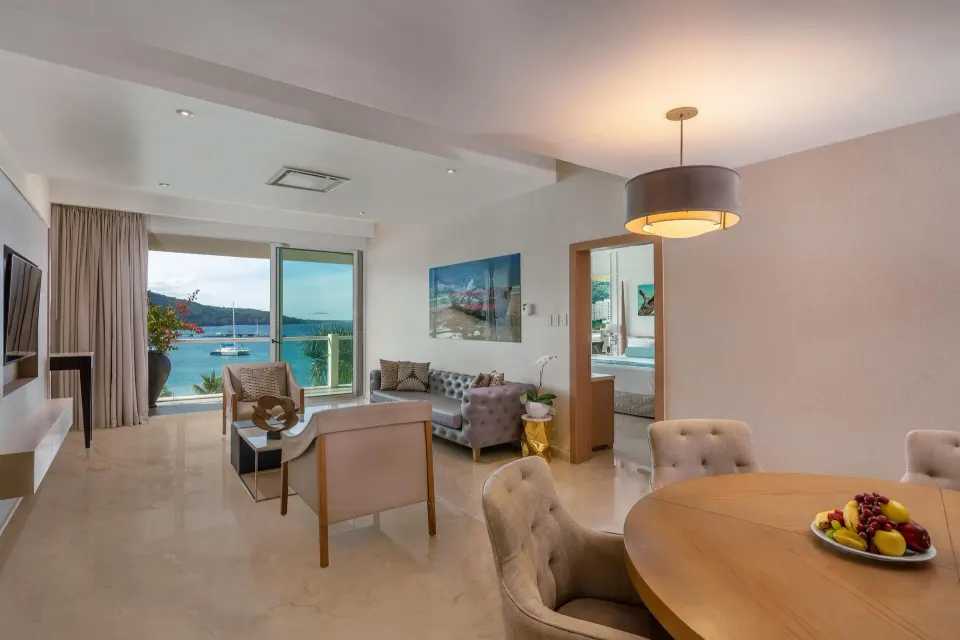 Superior Governor Suite ocean view living room at Moon Palace Jamaica with dining table and balcony.