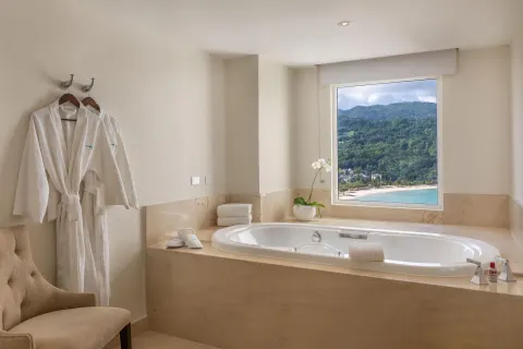 Soaking tub with ocean and hillside view in a presidential suite at Moon Palace Jamaica.