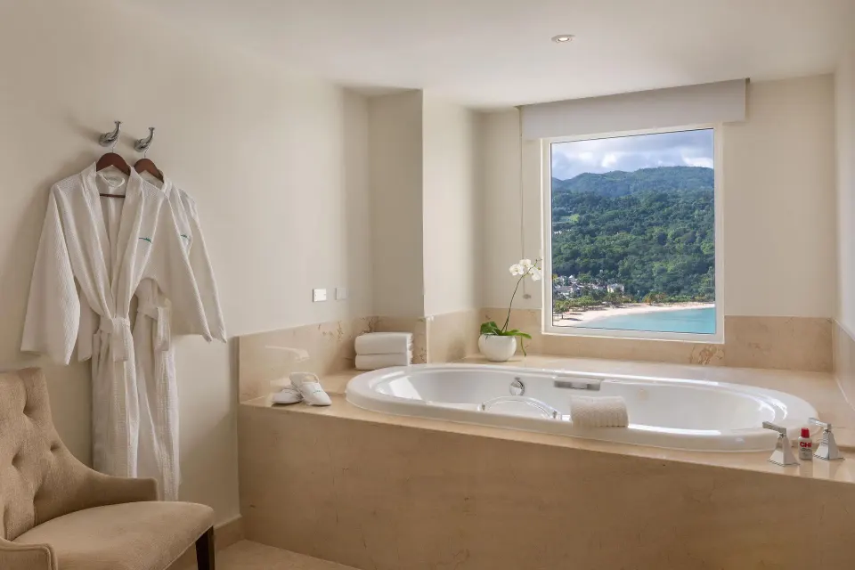 Soaking tub with ocean and hillside view in a presidential suite at Moon Palace Jamaica.