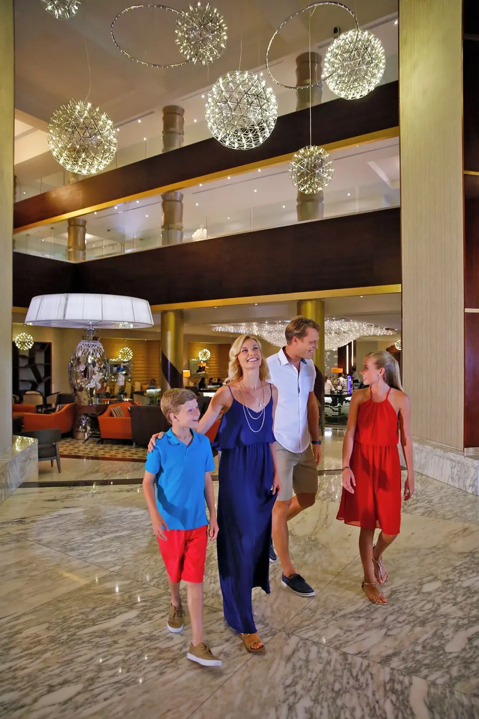 Family walking through the marble atrium lobby at Moon Palace Nizuc.