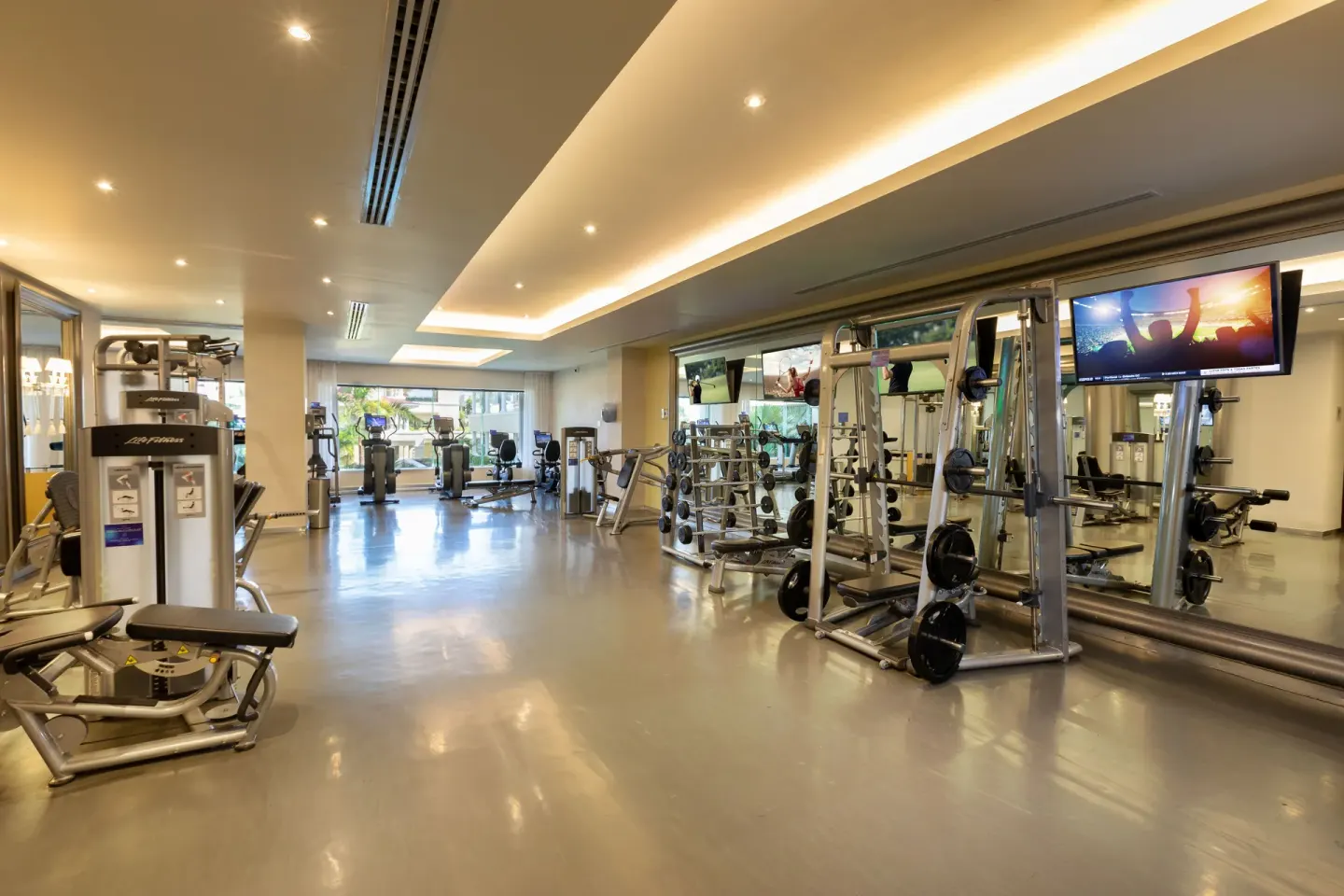 Fitness center with cardio machines, weights and mirrors at Moon Palace Nizuc.