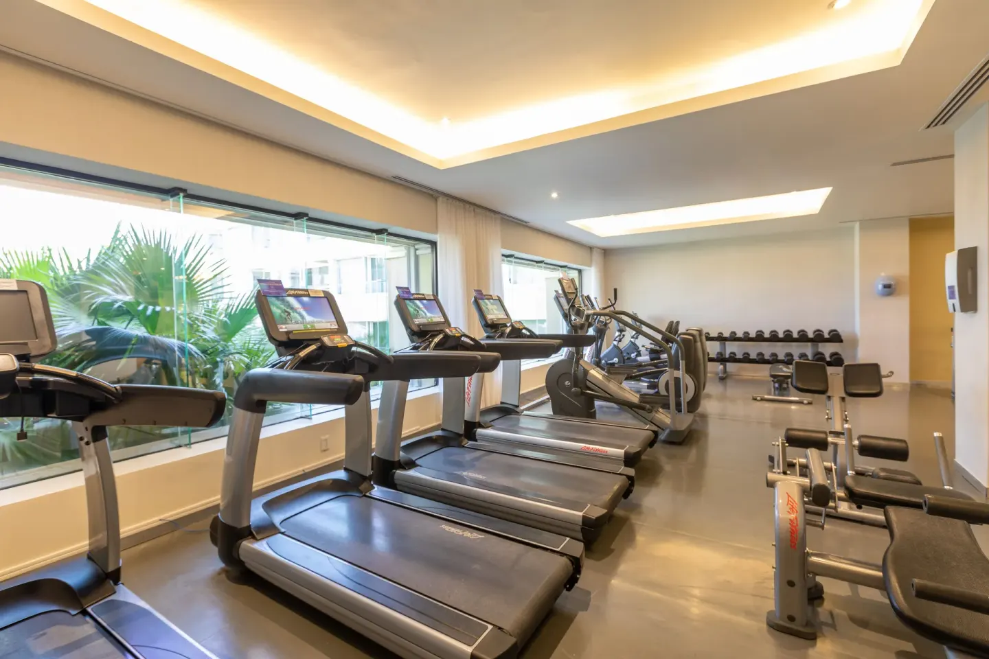 Fitness room with treadmills, weights, and exercise benches at Moon Palace Nizuc.
