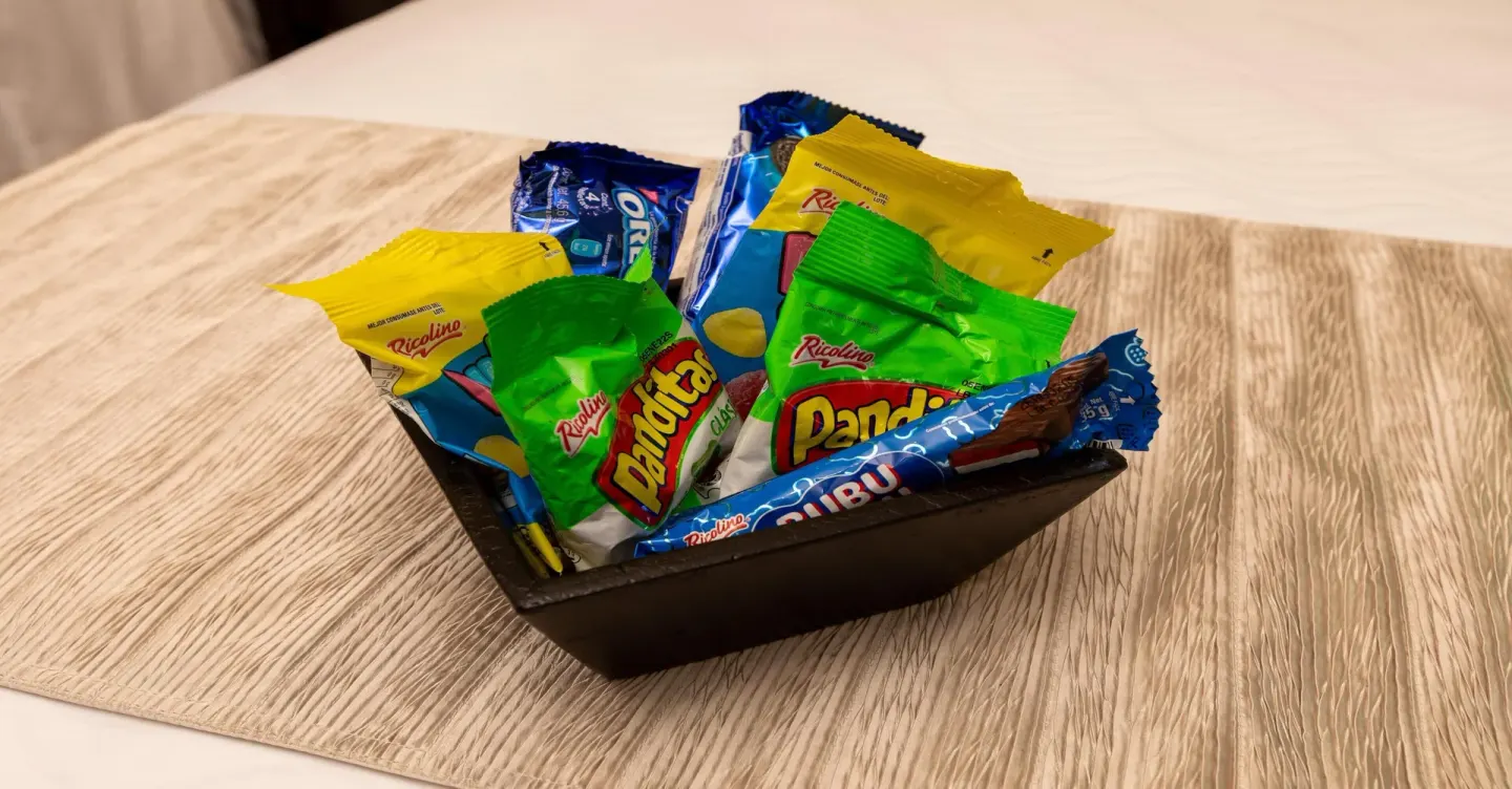 Basket of assorted packaged snacks on a bed at Moon Palace Nizuc.