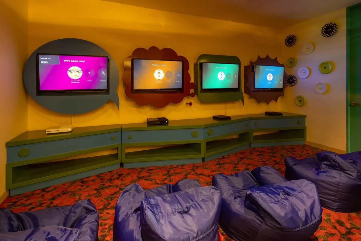 Kids gaming room with wall-mounted screens and beanbag seating at Moon Palace Nizuc.