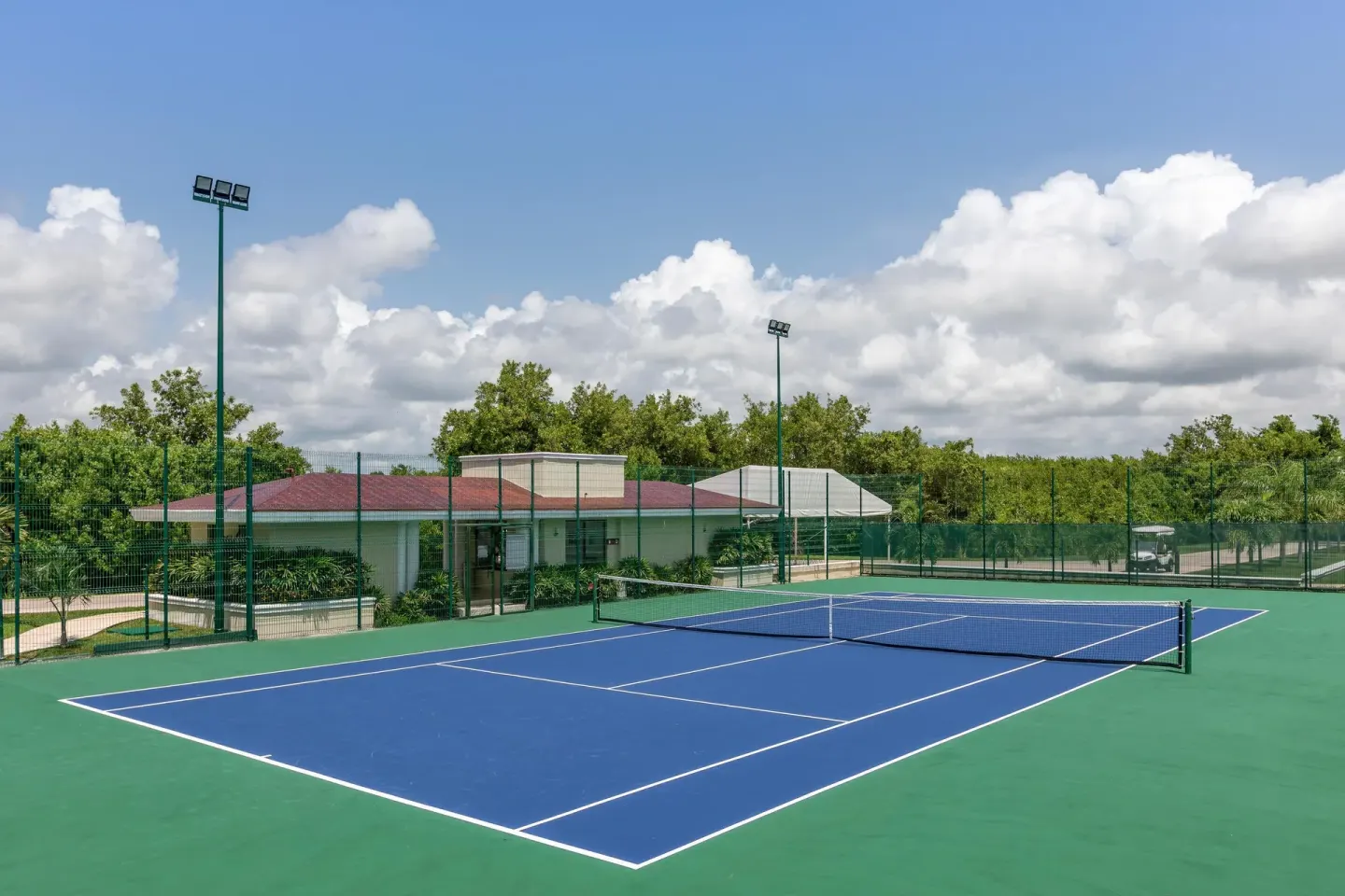 Outdoor tennis court with blue playing surface at Moon Palace Nizuc.