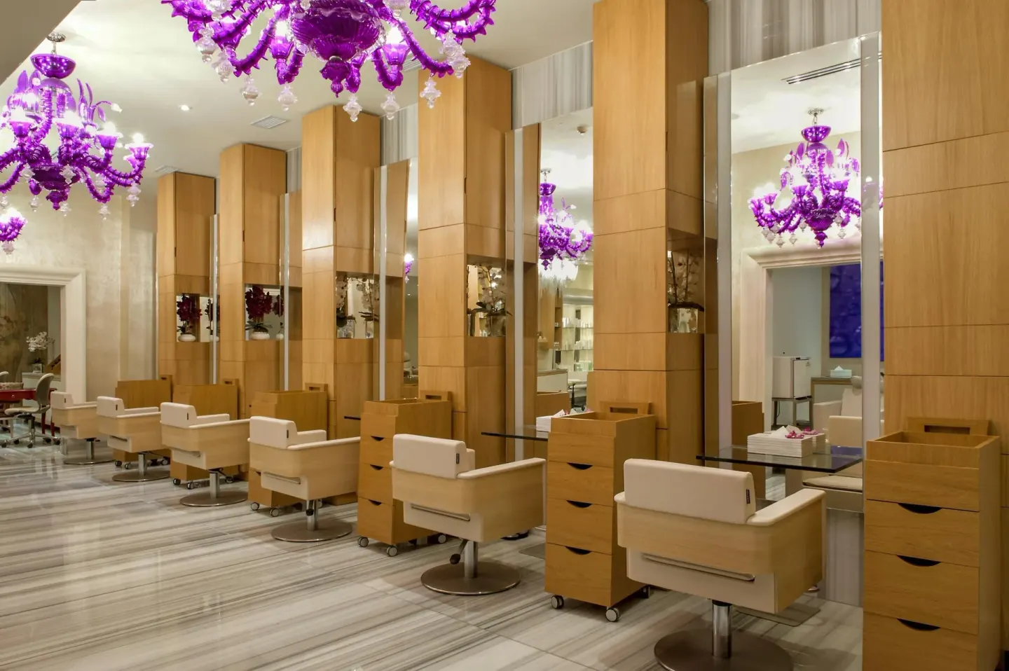 Salon styling stations with mirrors and purple chandeliers at Moon Palace Nizuc.