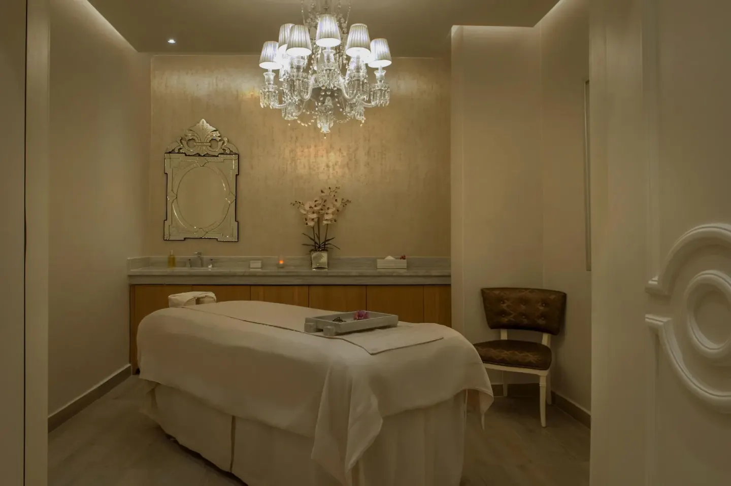 Spa treatment room with massage table and chandelier at Moon Palace Nizuc.
