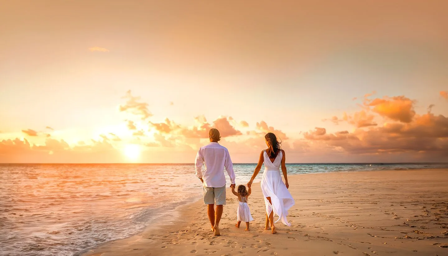 Family walking along the beach at sunset at Moon Palace Nizuc.