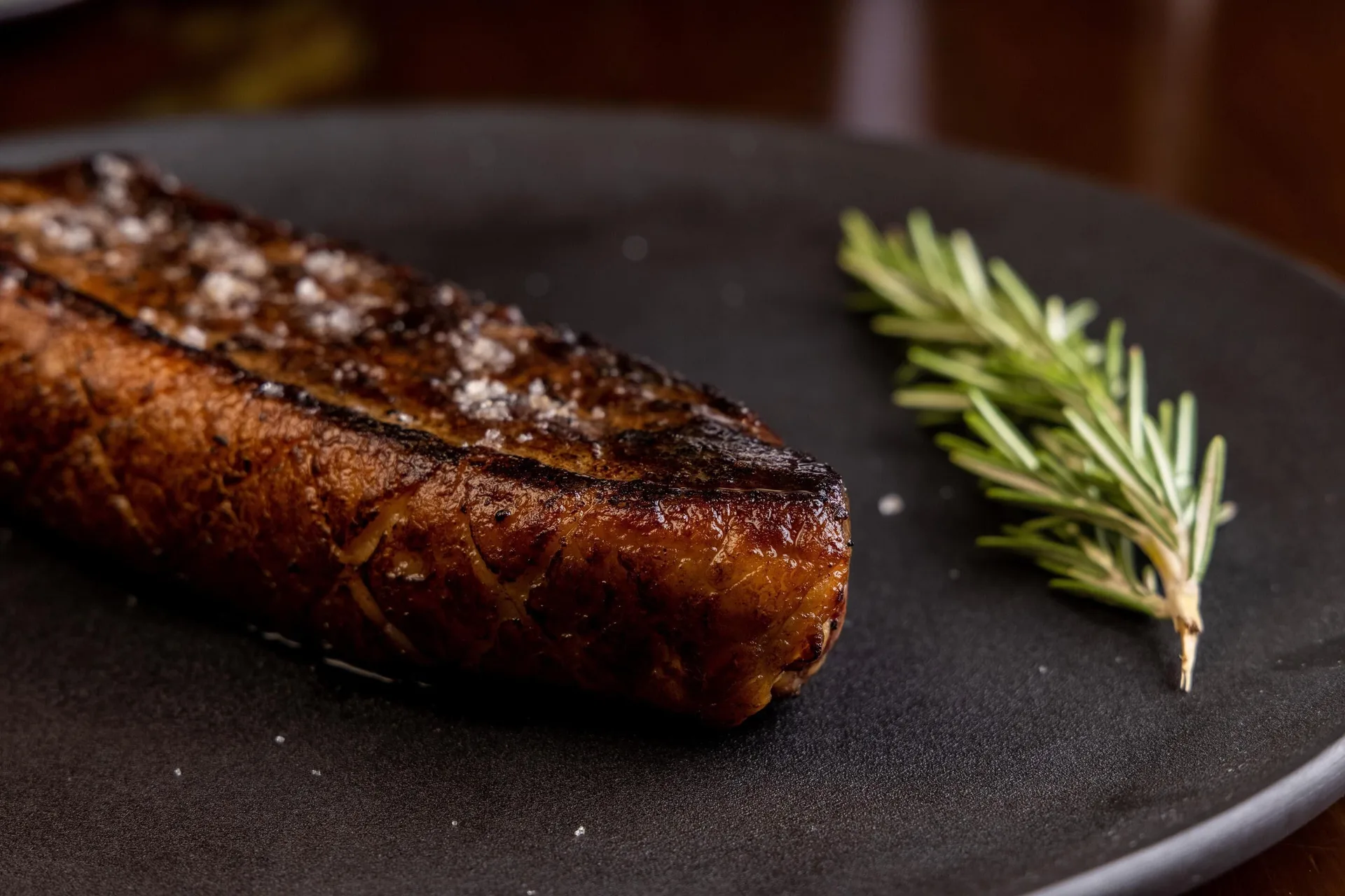 Grilled steak with rosemary on a black plate at Moon Palace Nizuc.