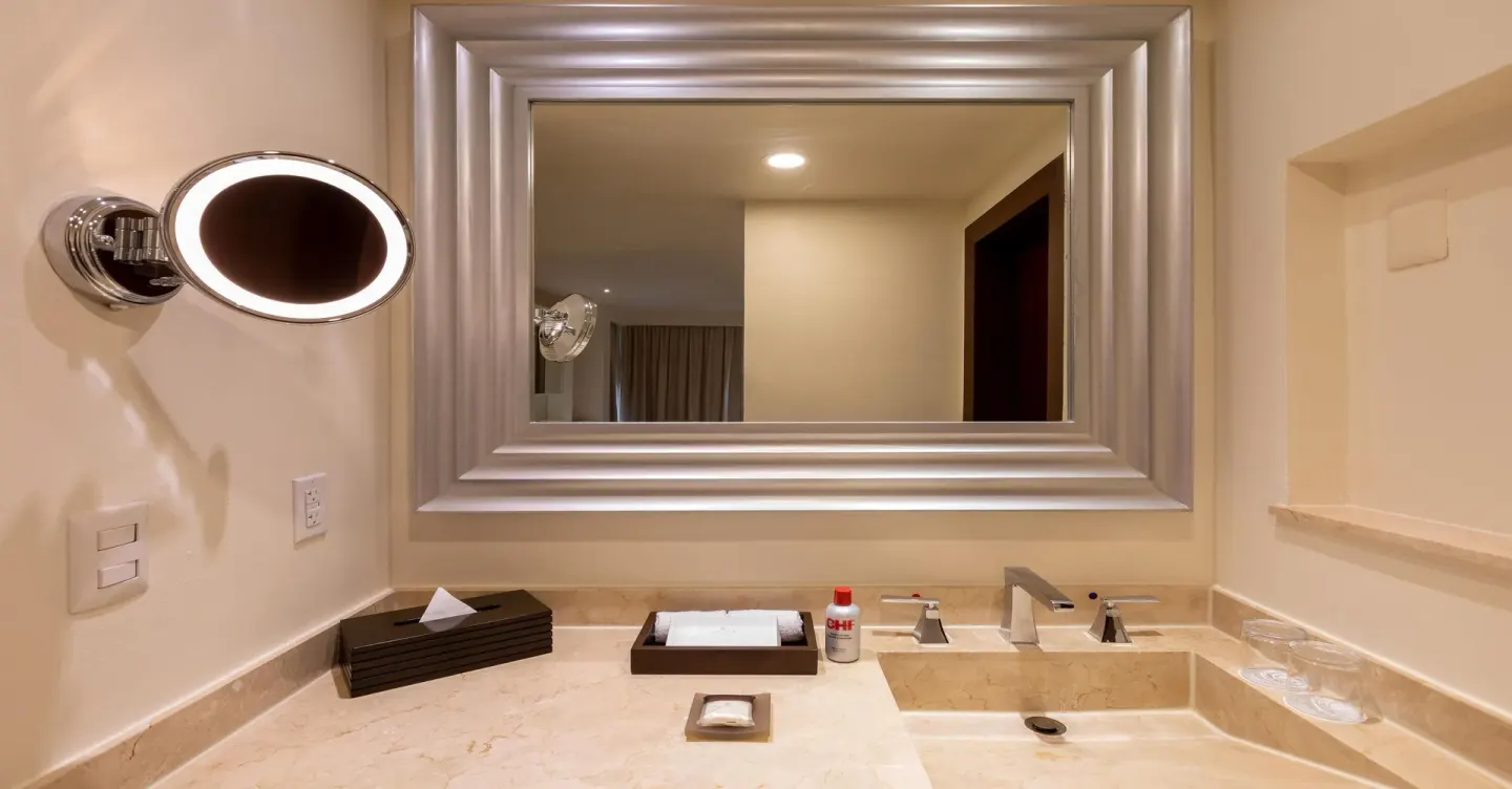 Guest bathroom vanity with large mirror at Moon Palace Nizuc.