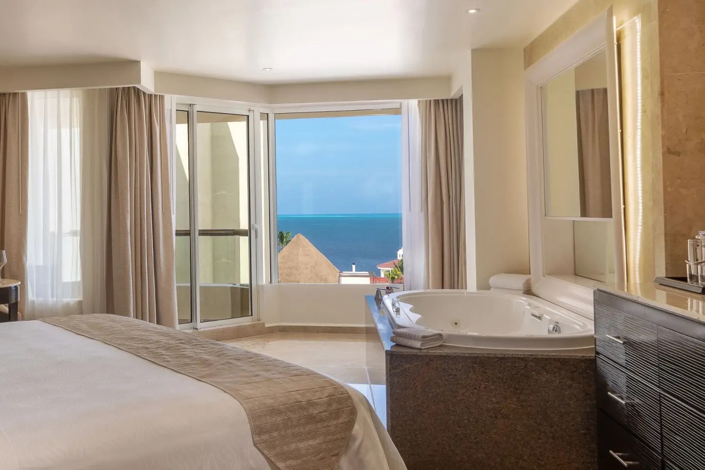Superior Deluxe Ocean View room with king bed, balcony doors, and tub at Moon Palace Nizuc.