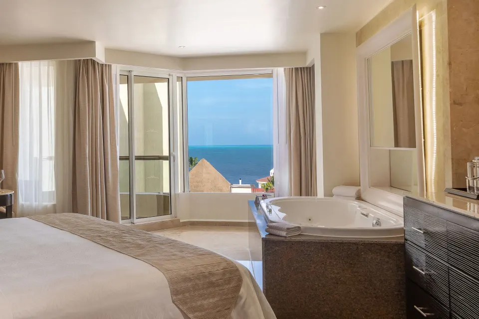 Superior Deluxe Ocean View room with king bed, balcony doors, and tub at Moon Palace Nizuc.