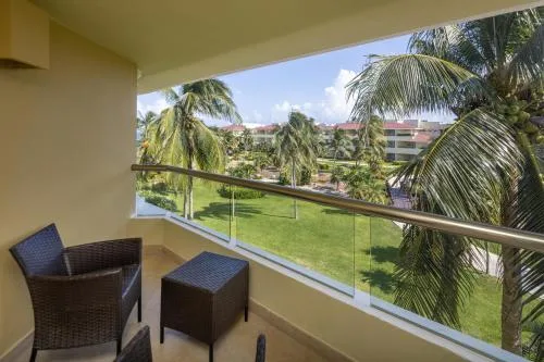 Suite balcony seating overlooking palms and resort grounds at Moon Palace Nizuc.