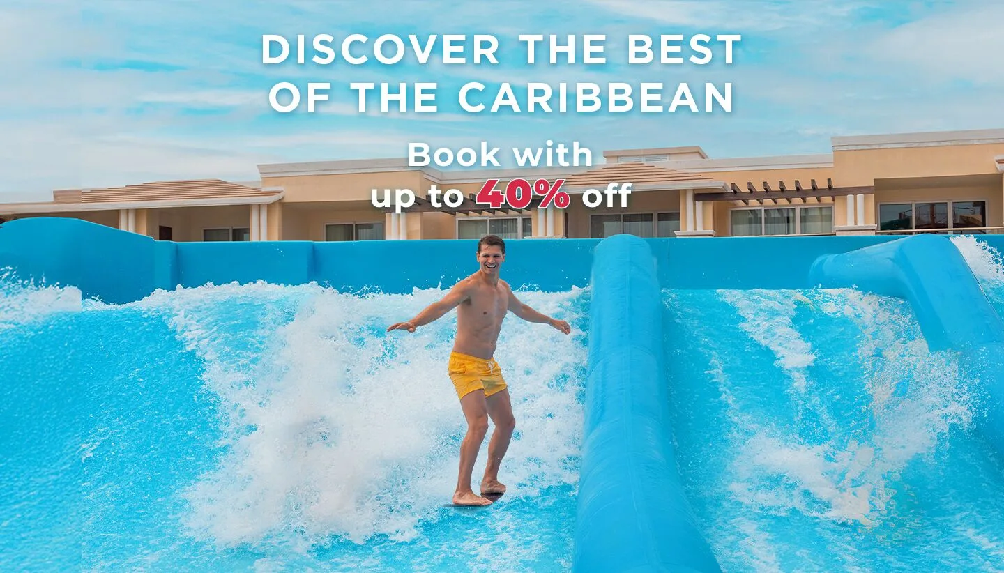 Guest riding an artificial surf wave with promotional text at Moon Palace The Grand Cancun.