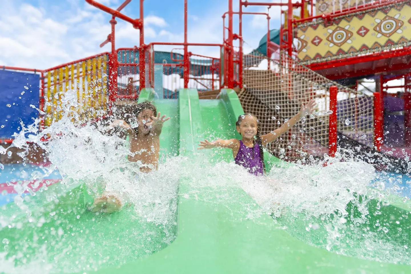 Children sliding down green water slides at Moon Palace The Grand Cancun.