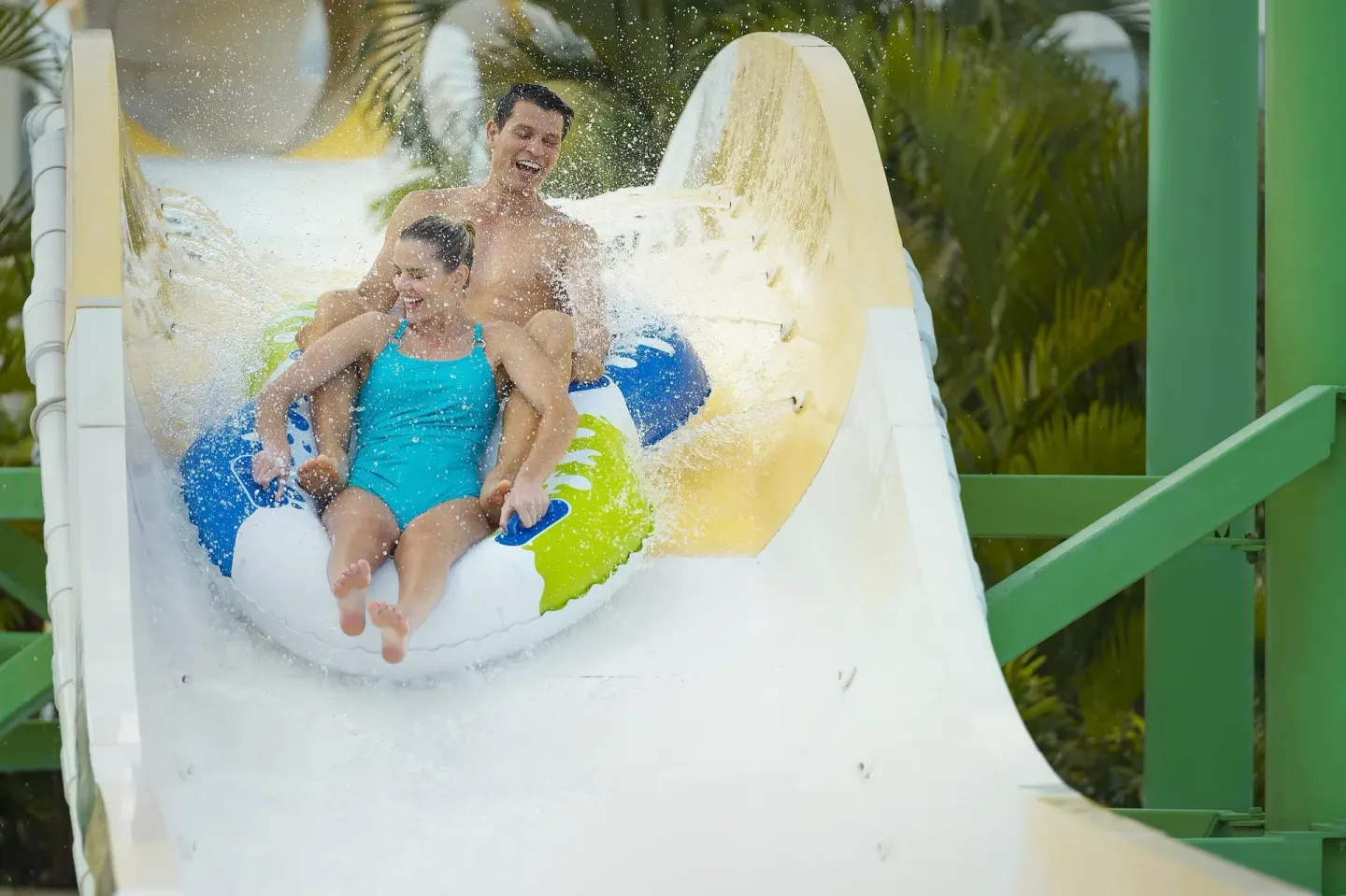 Adult and child riding an inflatable raft on a waterslide at Moon Palace The Grand Cancun.
