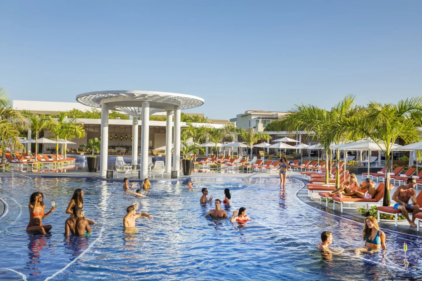 Resort pool with swimmers, cabanas, palms, and loungers at Moon Palace The Grand Cancun.