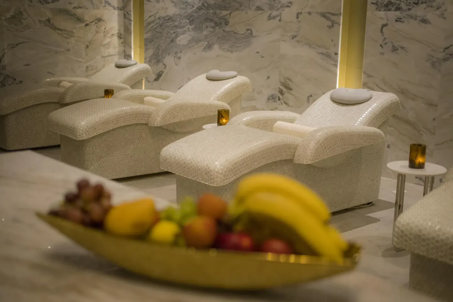 Curved spa loungers with small candle tables at Moon Palace The Grand Cancun.