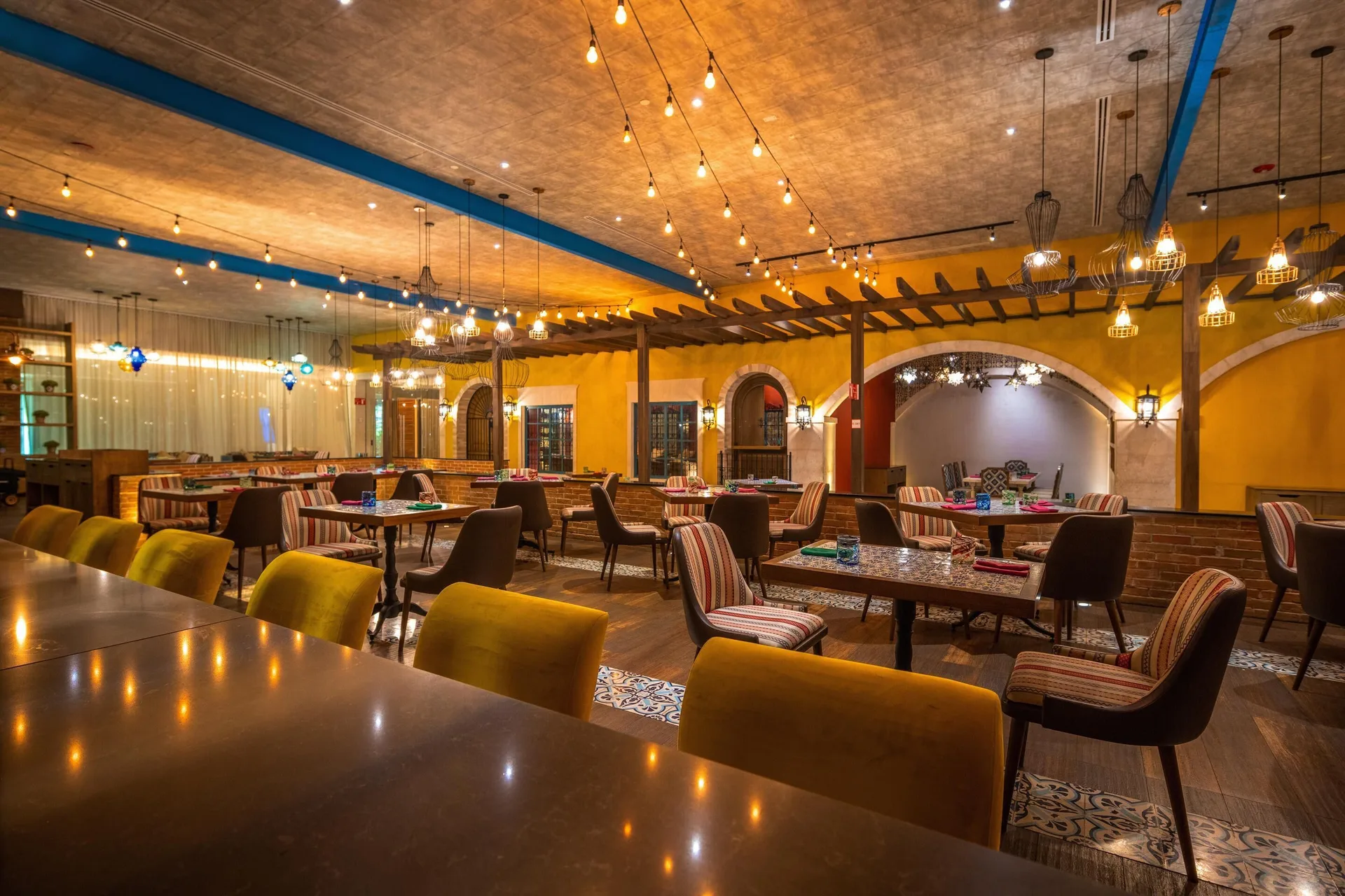 A colorful Mexican-style dining room with tiled tables at Moon Palace The Grand Cancun.