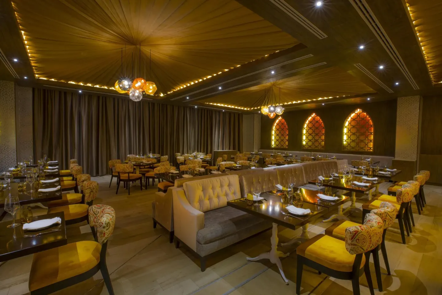 Warmly lit restaurant with patterned chairs at Moon Palace The Grand Cancun.