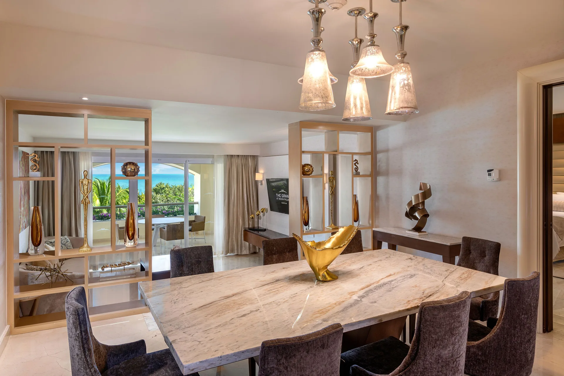 Grand Presidential Suite dining area at Moon Palace The Grand Cancun with marble table and living room beyond.