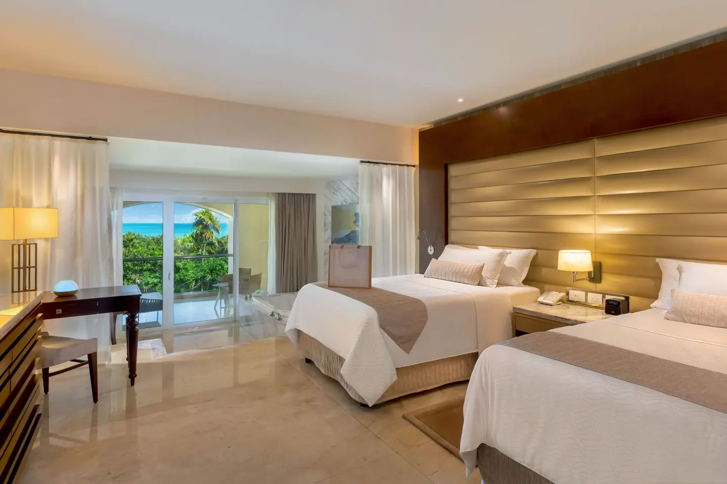 Grand Presidential Suite two-bed bedroom at Moon Palace The Grand Cancun with desk and balcony doors.