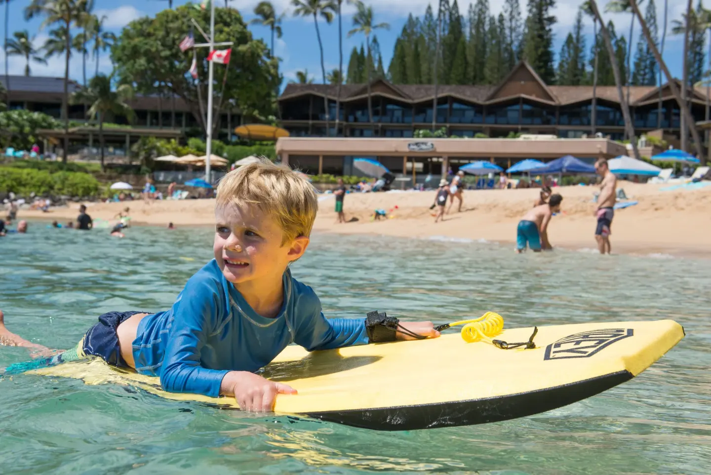 Child on a bodyboard in the ocean fronting Napili Kai Beach Resort.