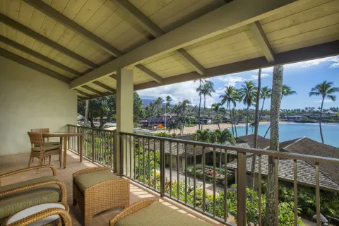 Covered lanai with wicker seating and bay views at Napili Kai Beach Resort.
