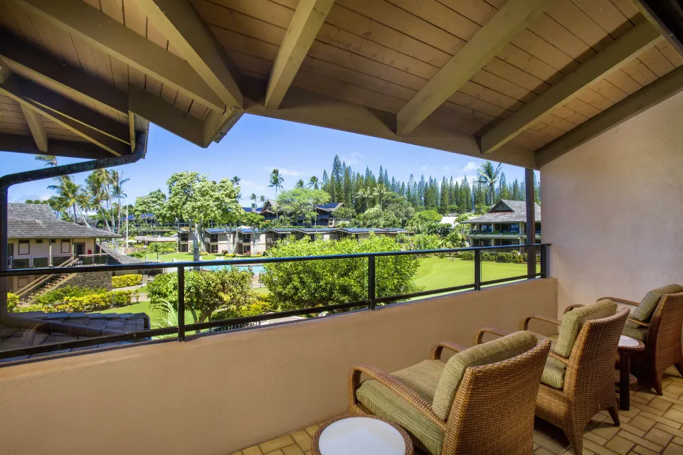 Covered lanai with chairs overlooking resort grounds at Napili Kai Beach Resort.