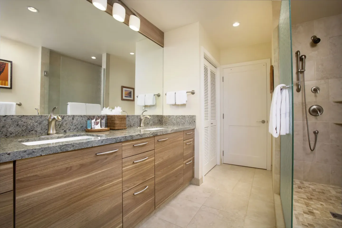 Bathroom with double vanity and glass shower at Napili Kai Beach Resort.