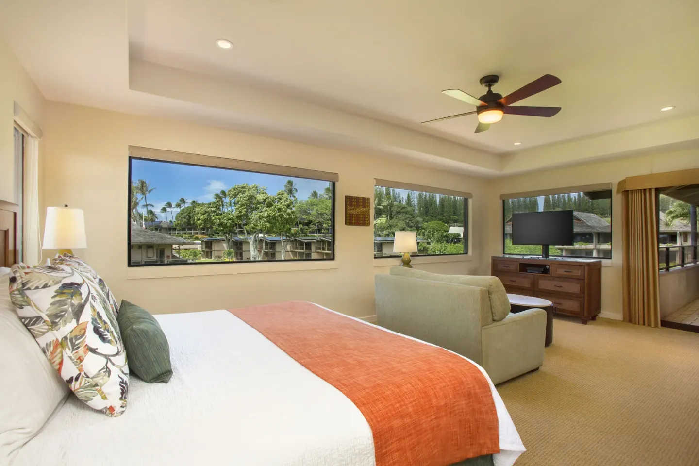 Guest room with bed, sitting area, and large windows at Napili Kai Beach Resort.