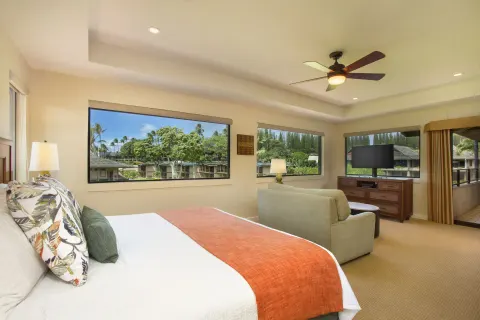 Guest room with bed, sitting area, and large windows at Napili Kai Beach Resort.