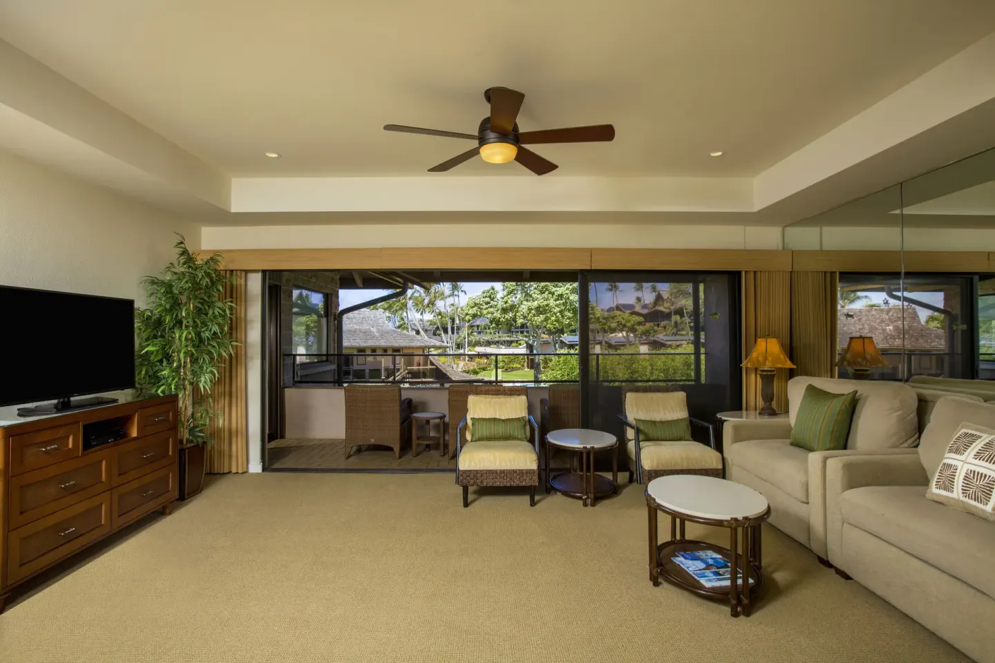 Living room with sofa, TV, and lanai at Napili Kai Beach Resort.