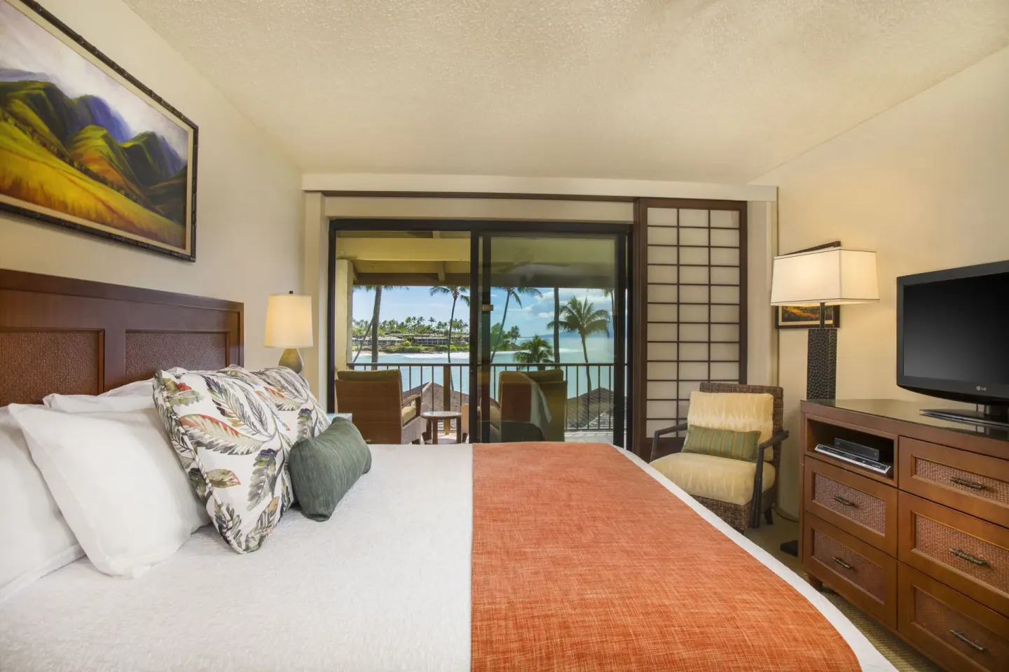 Guest room at Napili Kai Beach Resort with a king bed and balcony view toward the ocean.
