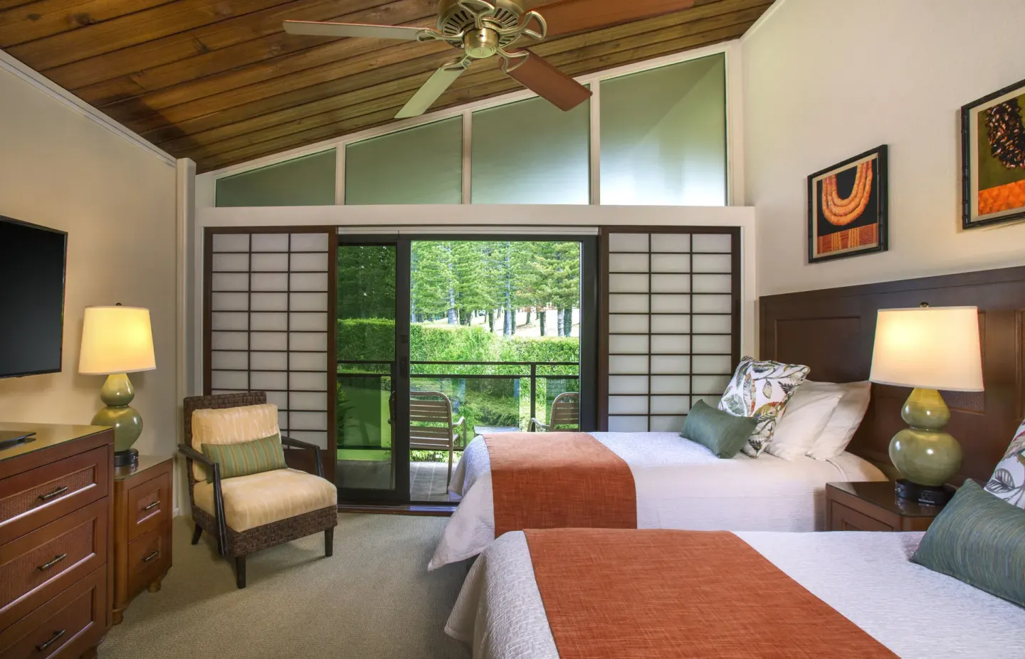 Guest room at Napili Kai Beach Resort with two beds, vaulted wood ceiling, and balcony doors.