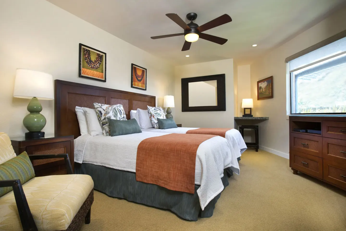 Guest room at Napili Kai Beach Resort with two beds, wood furniture, lamps, and a large window.