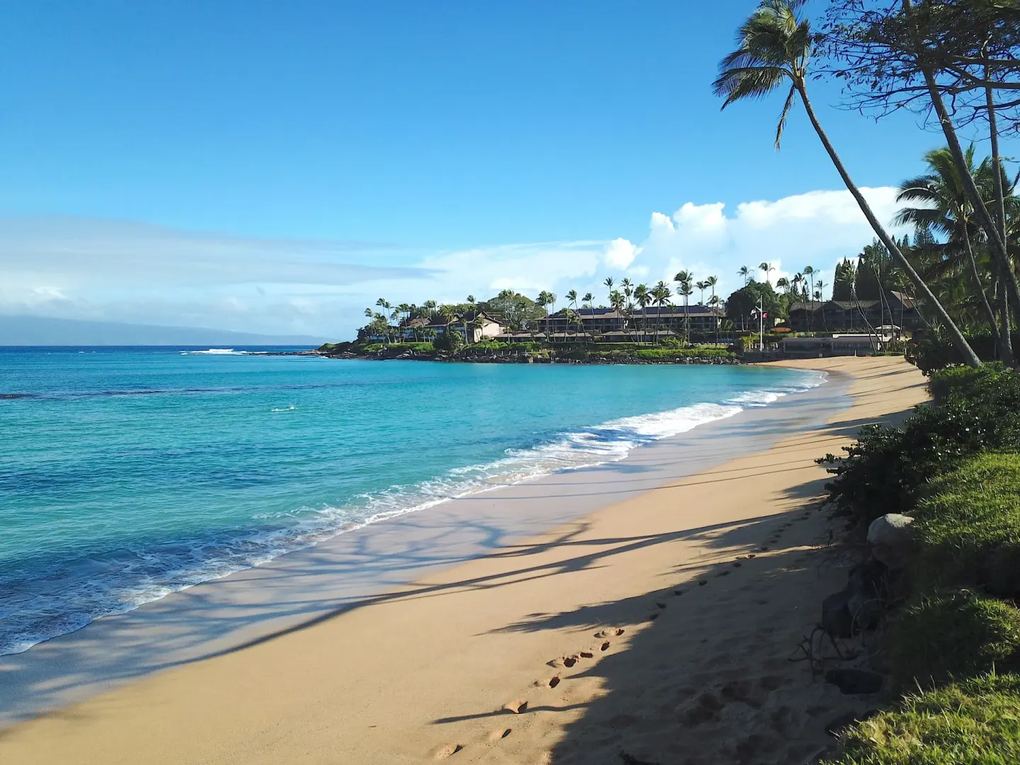 Wide sandy beach and turquoise water by Napili Kai Beach Resort.