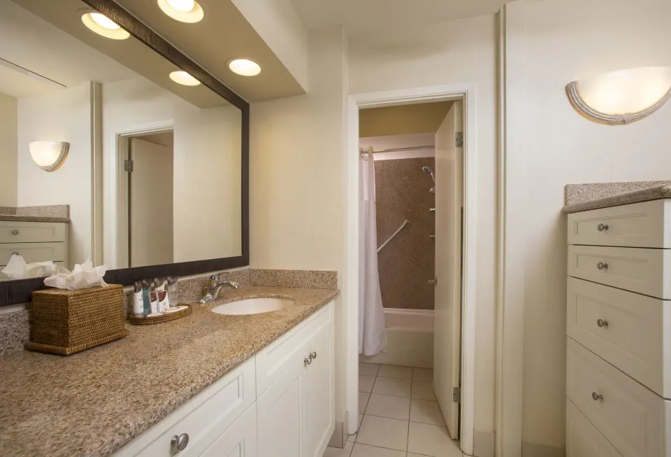 Deluxe Room bathroom vanity with shower room and storage cabinet at Napili Kai Beach Resort.