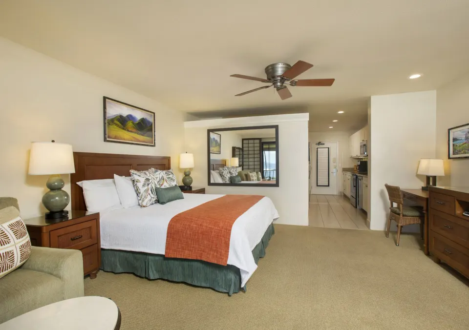 Deluxe Room with king bed, sitting chair, desk, and kitchenette at Napili Kai Beach Resort.