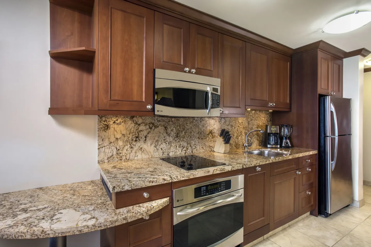 Studio kitchenette with wood cabinets and stainless appliances at Napili Kai Beach Resort.