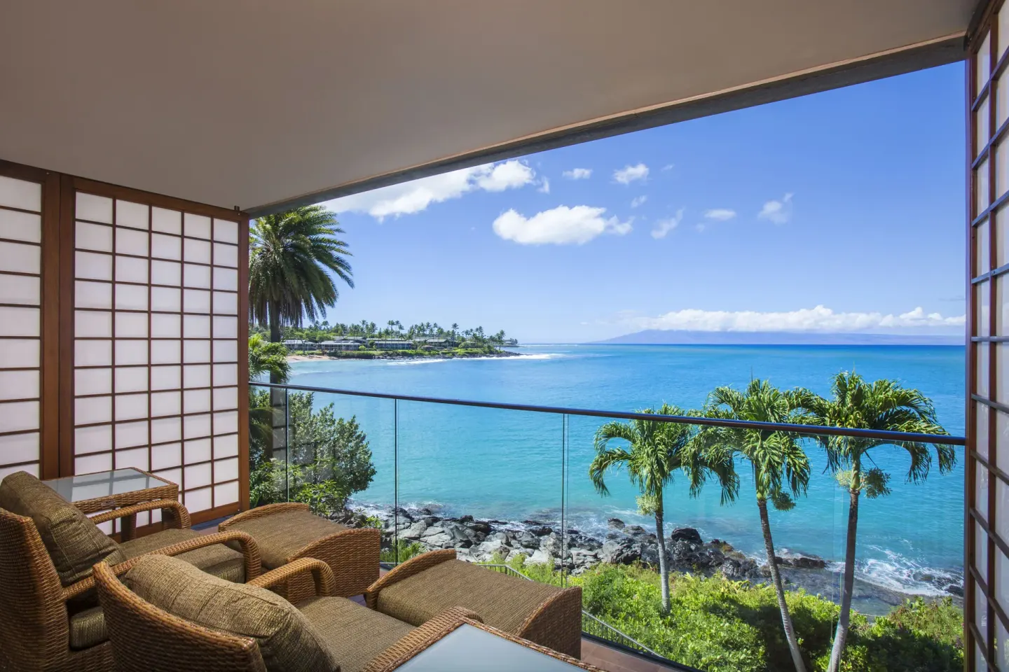 Oceanfront studio lanai with wicker seating and blue water views at Napili Kai Beach Resort.