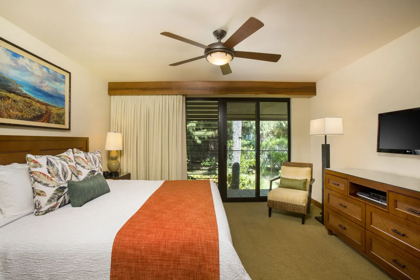 King bedroom with garden-facing sliding doors in an oceanfront suite at Napili Kai Beach Resort.