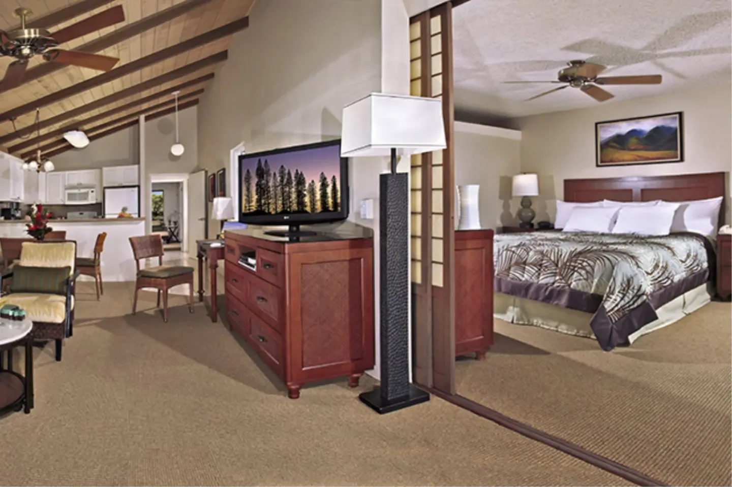Oceanfront suite living area and bedroom with king bed at Napili Kai Beach Resort.