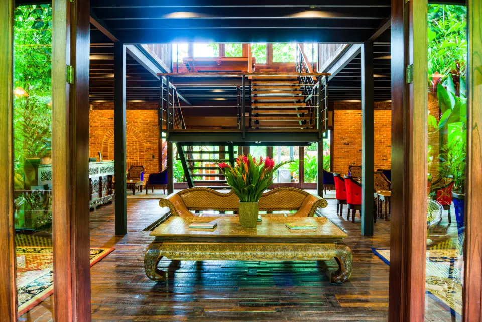 Open-air lobby lounge with wooden floors and tropical greenery at Nayara Springs.