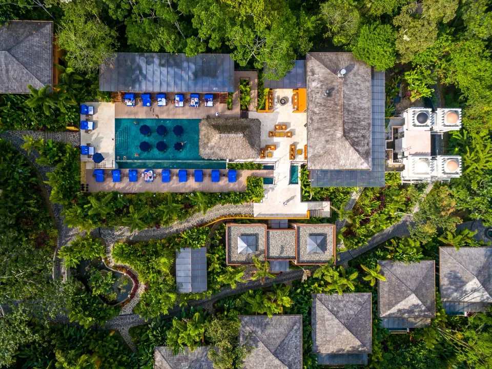 Top-down view of pool deck, loungers, and villas at Nayara Springs.