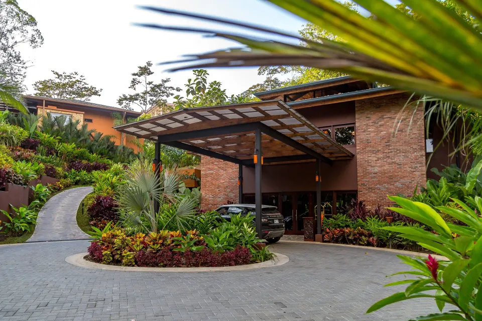 Covered resort entrance with landscaped driveway at Nayara Springs.